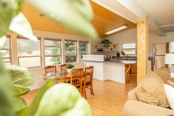 a living room with stainless steel appliances furniture and a large window
