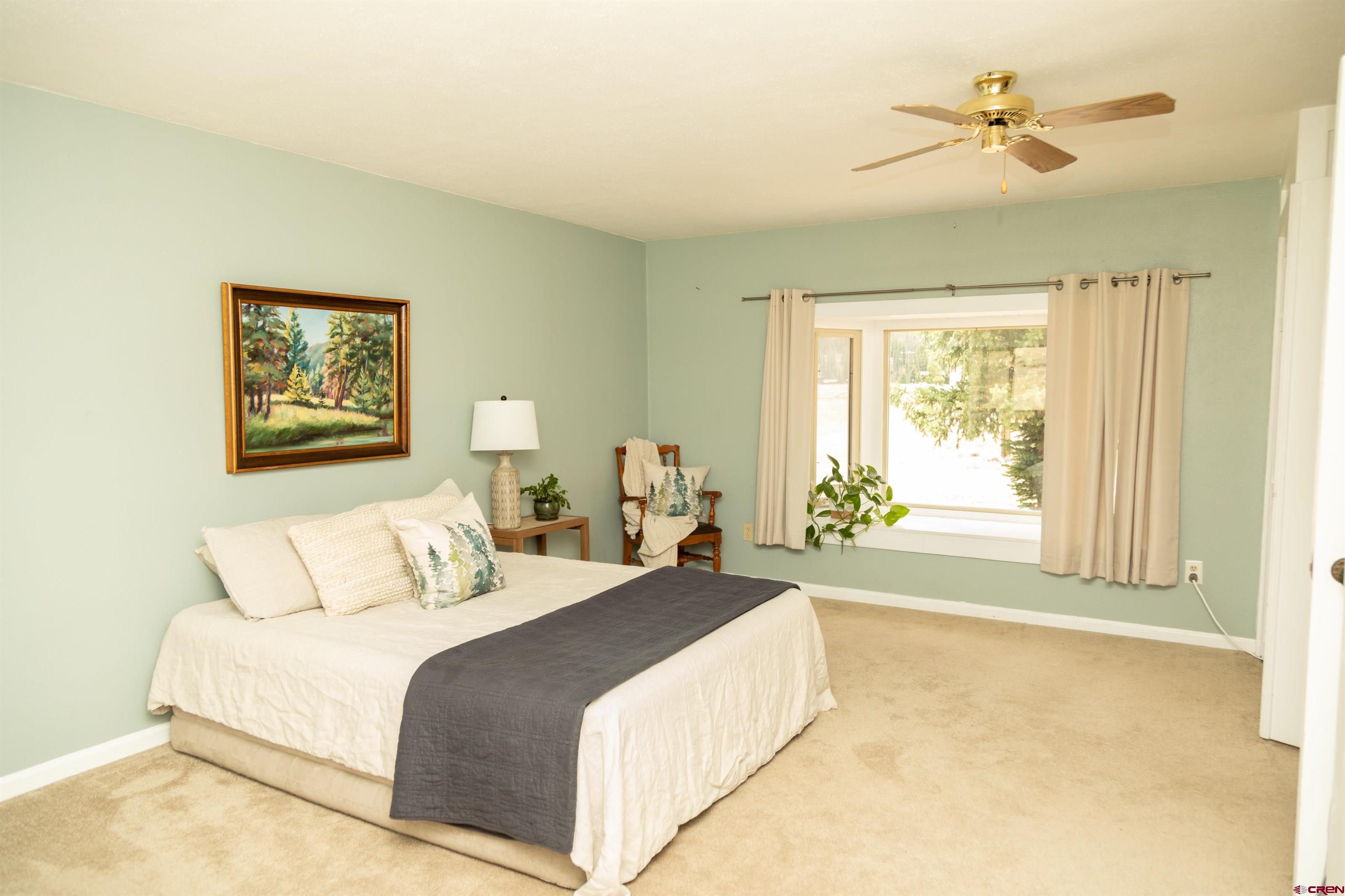 507 Ridge Drive Creede, CO 81130 - Photo 21 of 31 a bedroom with a large bed and a chandelier
