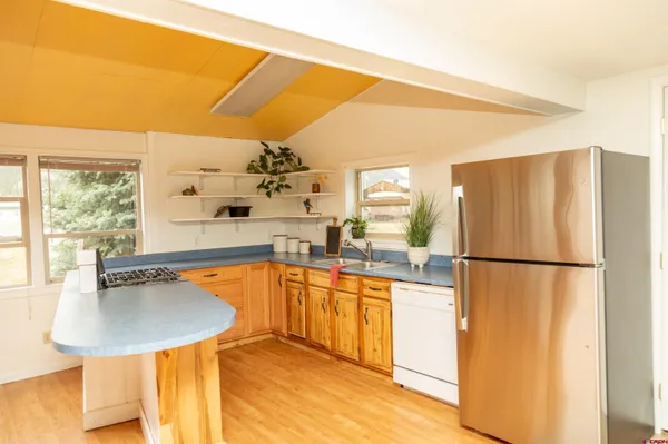 a kitchen with stainless steel appliances a refrigerator a sink a stove and white cabinets