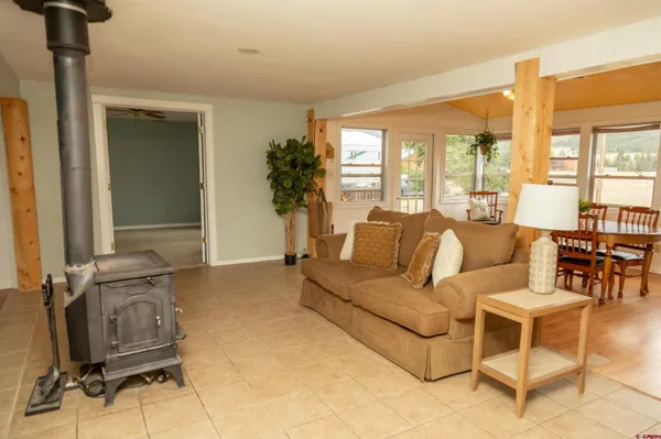 a living room with furniture a floor to ceiling window and a flat screen tv