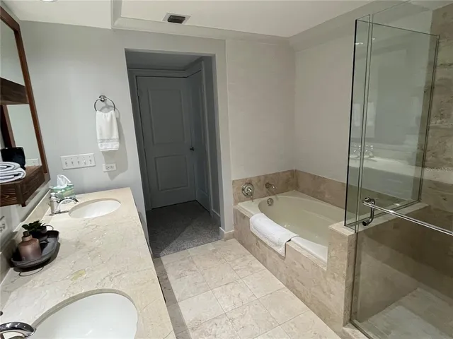 a bathroom with a tub a mirror and a shower