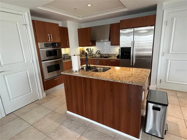 a kitchen with granite countertop a refrigerator and a sink