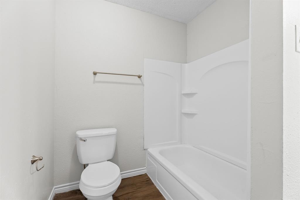 429 Johnson Street Longview, TX 75602 - Photo 12 of 26 a white toilet sitting next to a bath tub