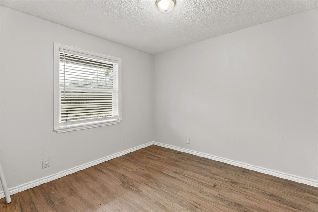 429 Johnson Street Longview, TX 75602 - Photo 9 of 26 wooden floor in an empty room with a window