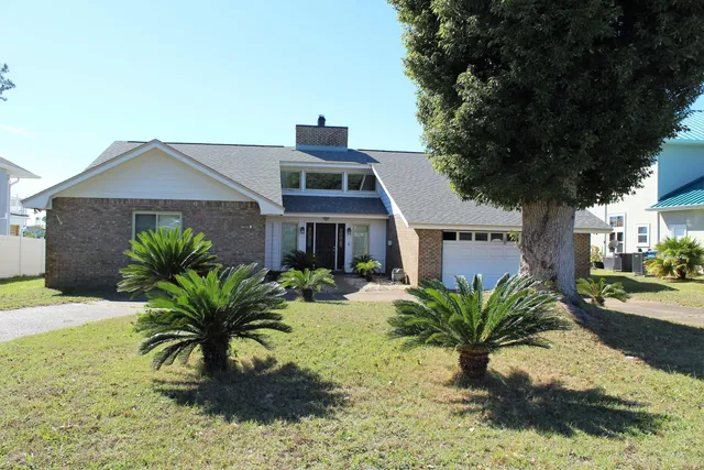 a front view of house with yard and trees around