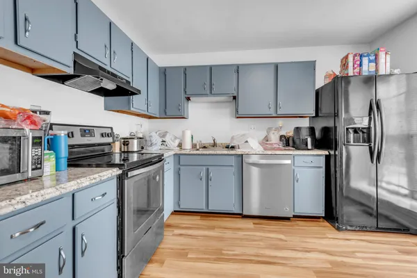a kitchen with a sink stainless steel appliances and white cabinets