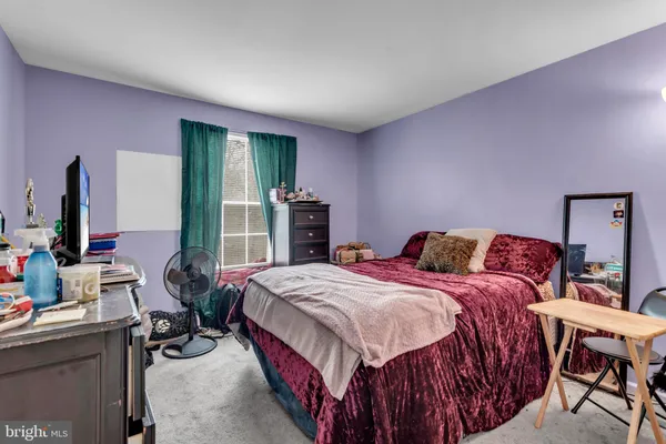 a bedroom with a bed and large windows