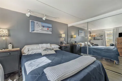 a large bedroom with a bed and wooden floor