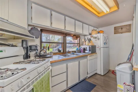 a kitchen with appliances a sink and cabinets