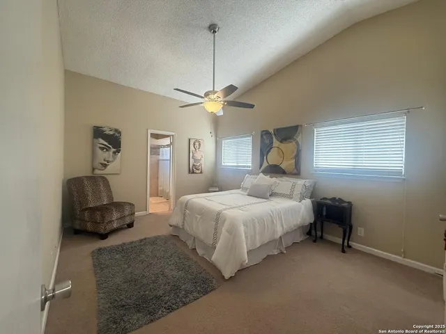a bedroom with a bed couch and chandelier
