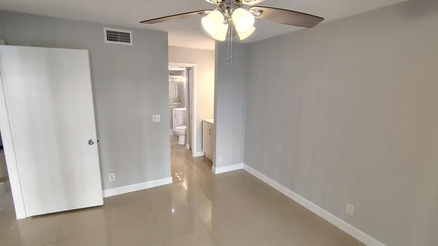 a view of an empty room with a chandelier fan