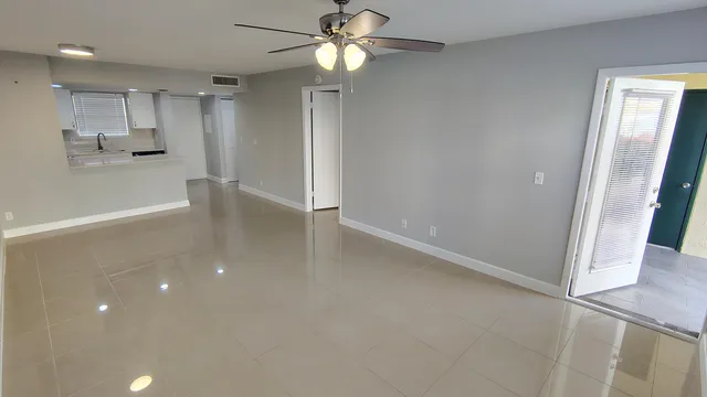 a view of a kitchen with wooden floor and a ceiling fan