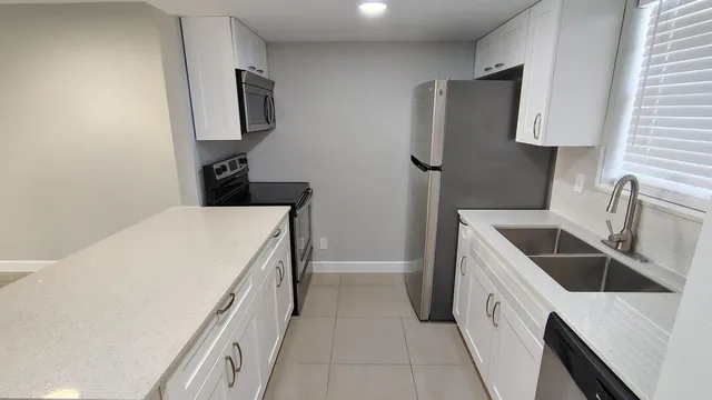 a kitchen with a refrigerator and a sink