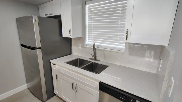 a kitchen with metallic refrigerator and sink