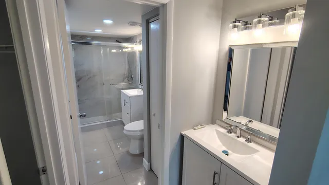 a bathroom with a sink a toilet and shower