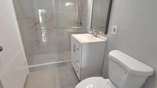 a bathroom with a sink a toilet and shower