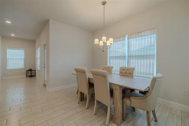 a kitchen with stainless steel appliances kitchen island granite countertop a table chairs and a refrigerator