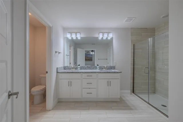 a bathroom with a granite countertop sink a mirror and a shower