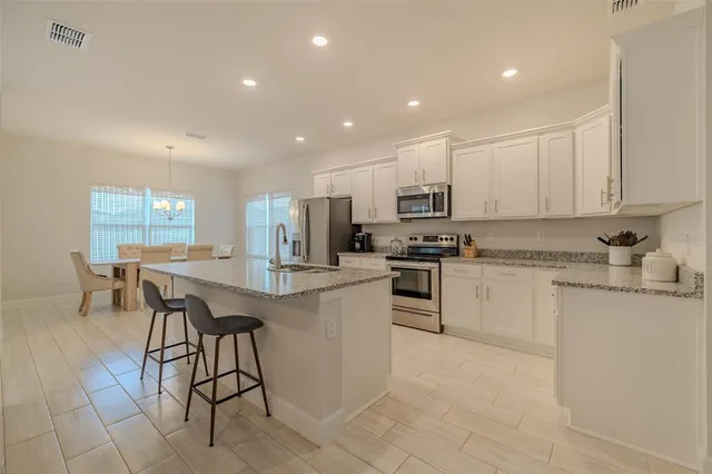 a kitchen with granite countertop a sink stove and refrigerator