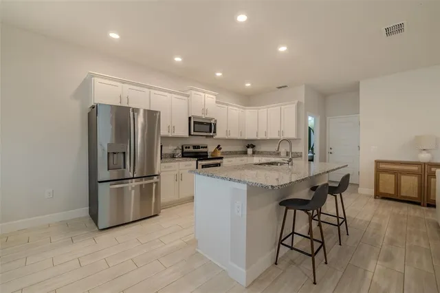 a living room with furniture a flat screen tv and kitchen view
