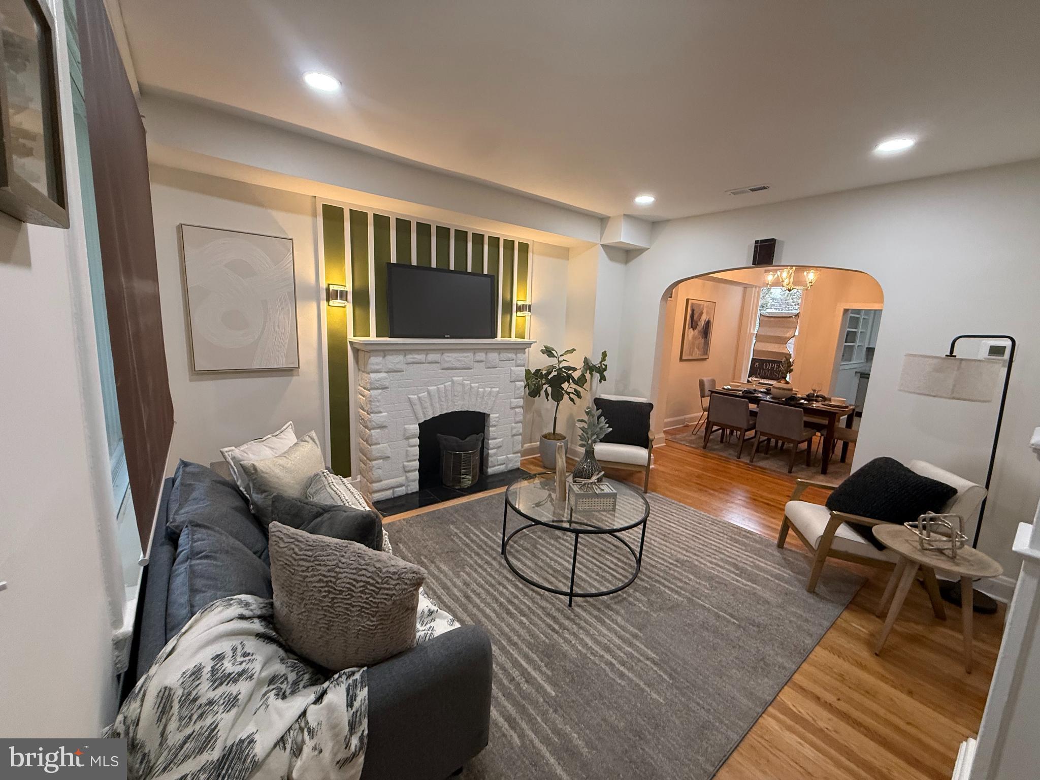 a living room with furniture a fireplace and a flat screen tv