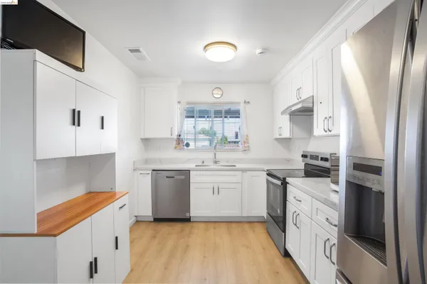 a kitchen with granite countertop white cabinets and white appliances