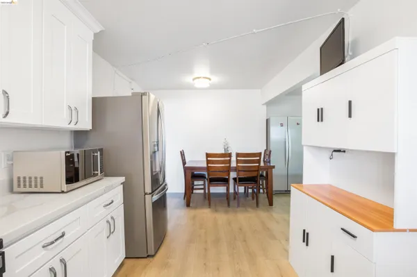 a living room with furniture a flat screen tv and kitchen view