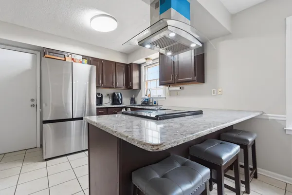 a kitchen with stainless steel appliances granite countertop a sink refrigerator and cabinets