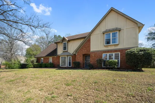 a view of house with a yard
