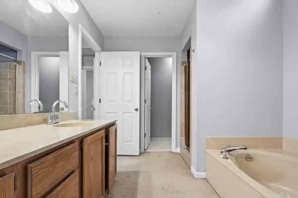 a bathroom with a tub sink and mirror