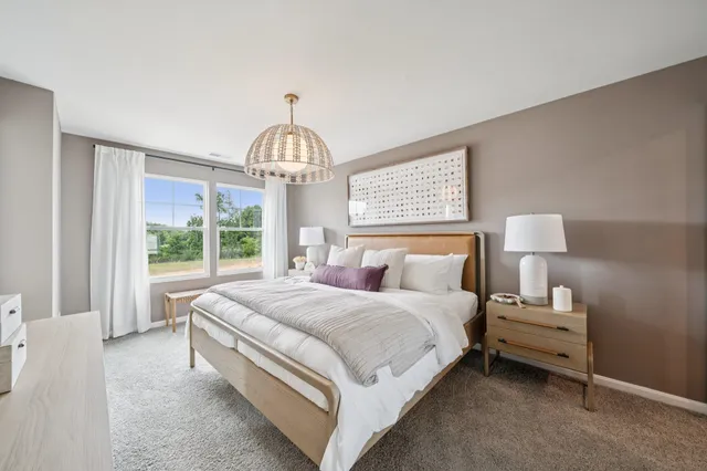 a spacious bedroom with a large bed and a chandelier