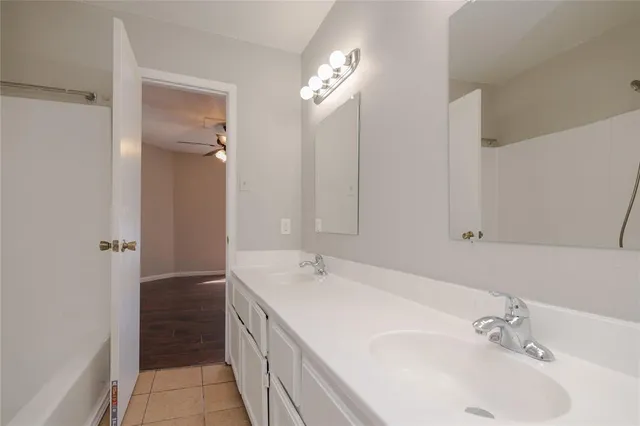 a bathroom with a double vanity sink and a mirror