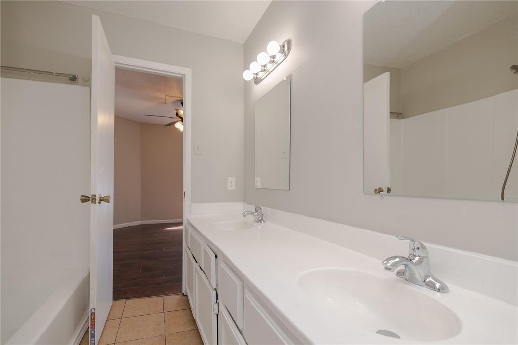2821 Wimbledon Court Garland, TX 75041 - Photo 12 of 27 a bathroom with a double vanity sink and a mirror