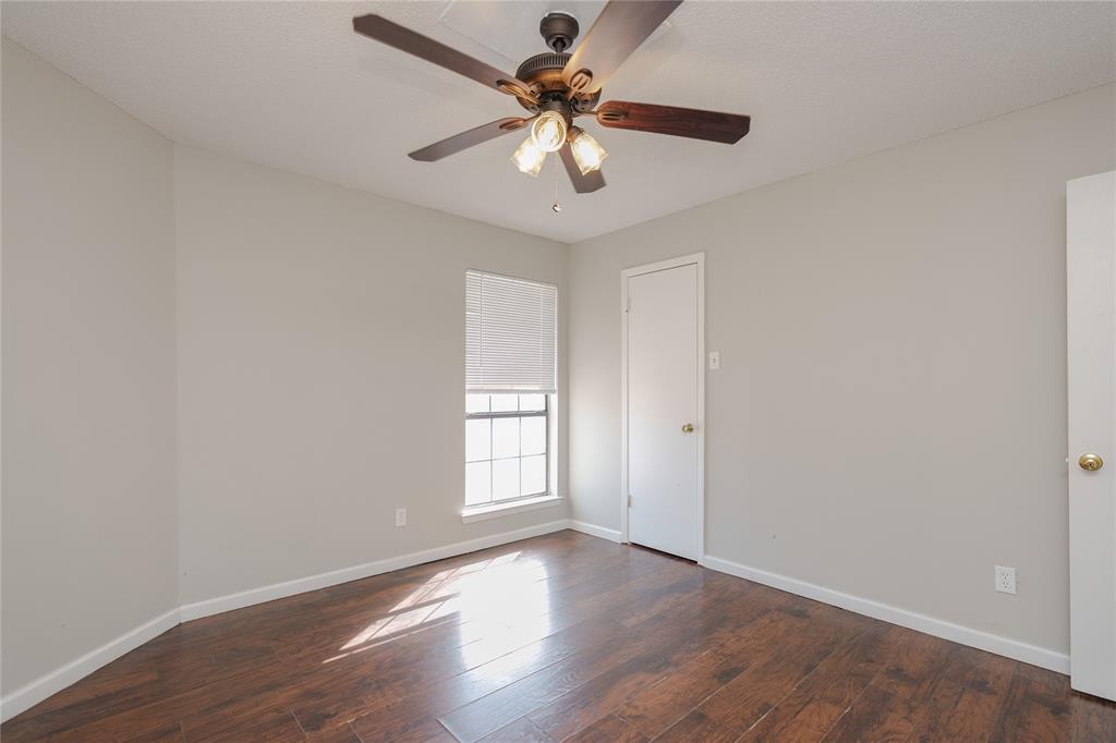 2821 Wimbledon Court Garland, TX 75041 - Photo 14 of 27 a view of an empty room with window and wooden floor
