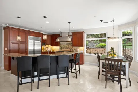 a kitchen with stainless steel appliances granite countertop a sink a stove and a refrigerator