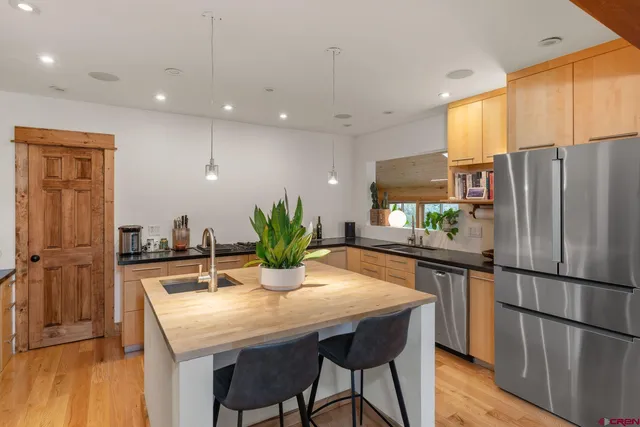 a kitchen with a sink a counter space and a dining table