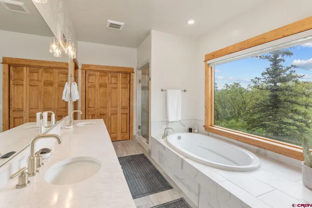 a spacious bathroom with a tub shower and a sink