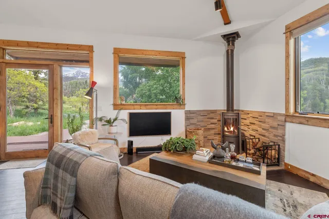 a living room with patio furniture and a floor to ceiling window
