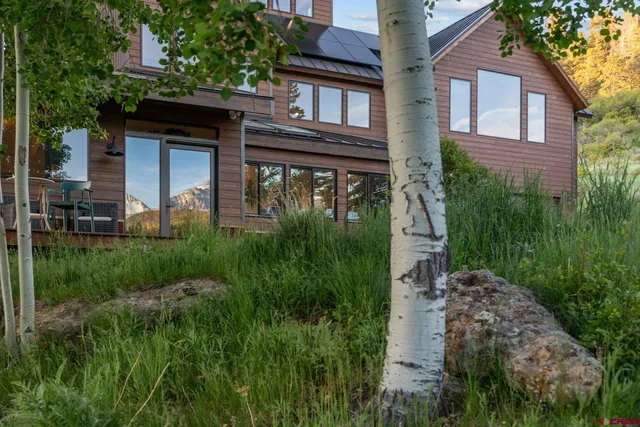 a living room with furniture a wooden floor and kitchen view