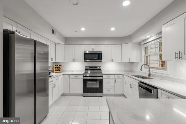 a kitchen with stainless steel appliances granite countertop a refrigerator sink and stove