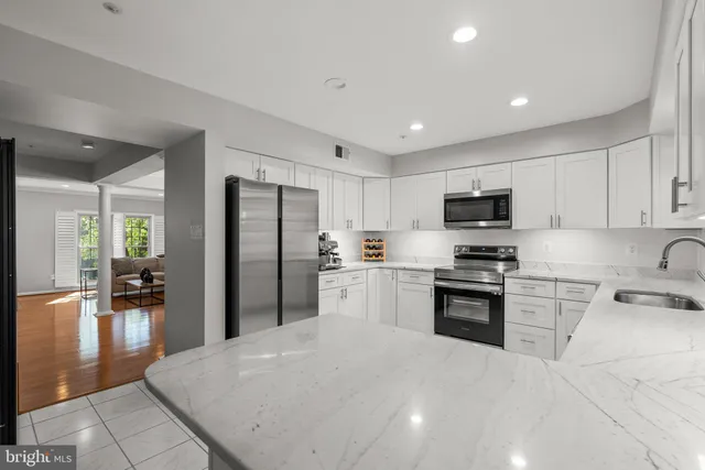 a kitchen with granite countertop a refrigerator stove top oven and sink