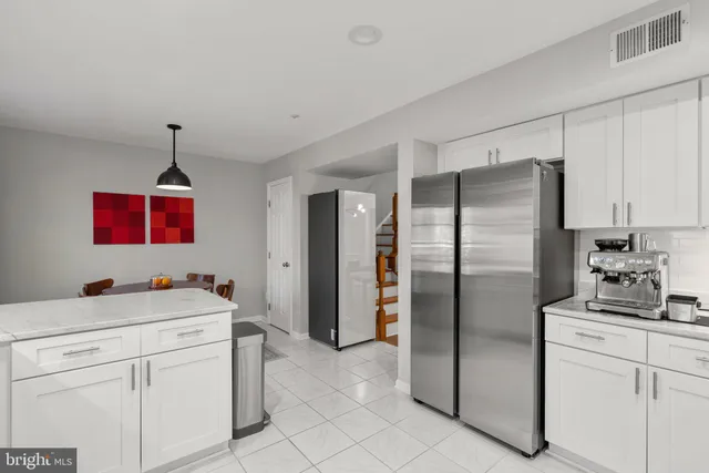 a kitchen with a refrigerator sink and cabinets