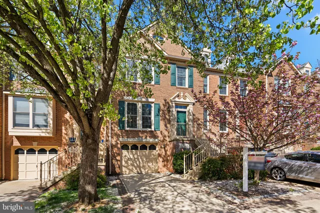 a front view of a house with a tree