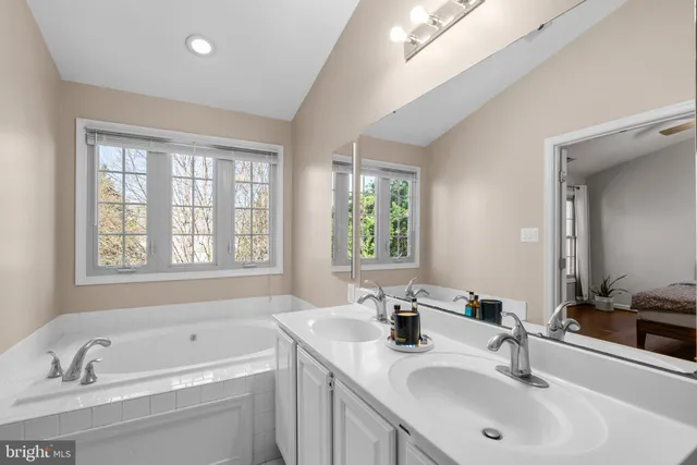 a bathroom with a sink double vanity tub and a window