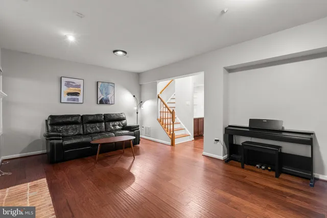 a living room with furniture and a wooden floor