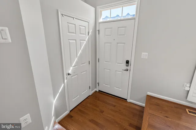 a view of a hallway with wooden floor and entryway