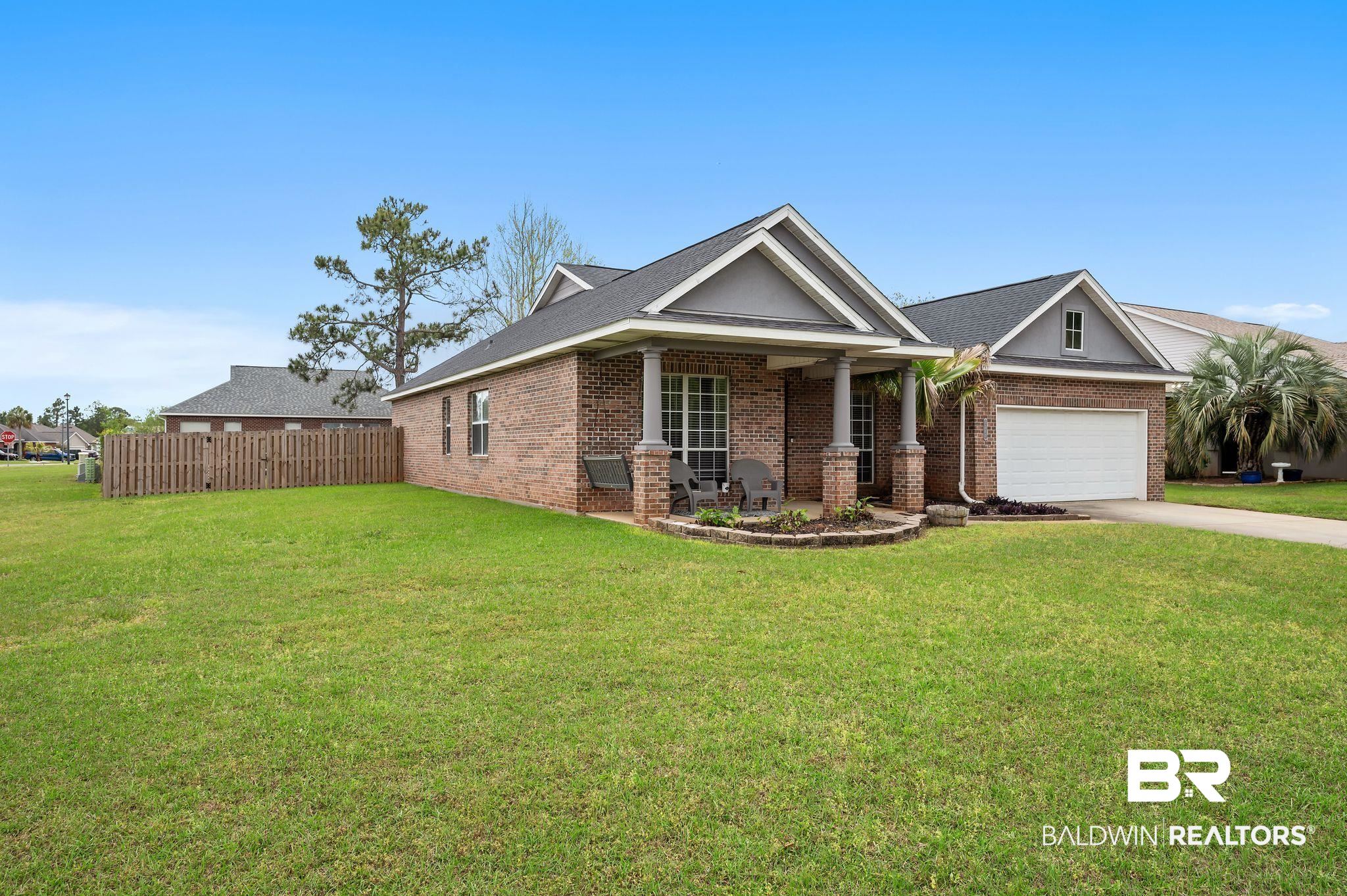 1287 Pembroke Way Foley, AL 36535 - Photo 3 of 39 View of front of home with brick siding, driveway, an attached garage, covered porch, and a shingled roof