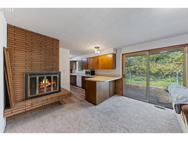 a living room with furniture a fireplace and a floor to ceiling window