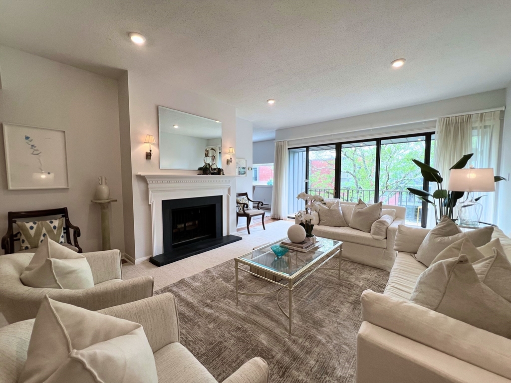 a living room with furniture a large window and a fireplace