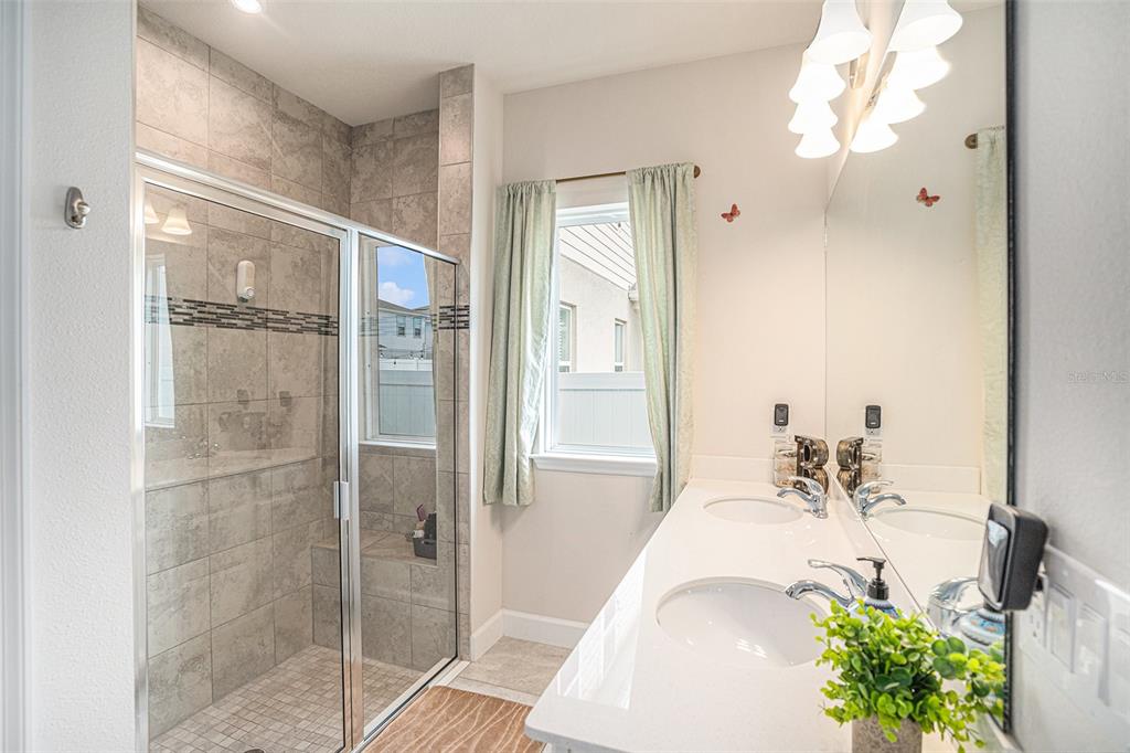 19056 Heavenside Ct Spring Hill Spring Hill, FL 34610 - Photo 13 of 25 a en suite bathroom with a double vanity sink and mirror